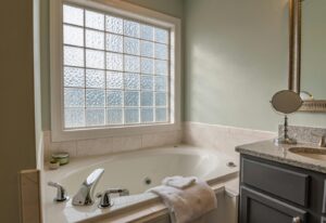 Stylish modern bathroom featuring a luxury bathtub, sleek sink, and large window. Perfect for relaxation.