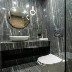 Luxurious bathroom interior featuring sleek marble walls, floating sink, and a contemporary toilet design.
